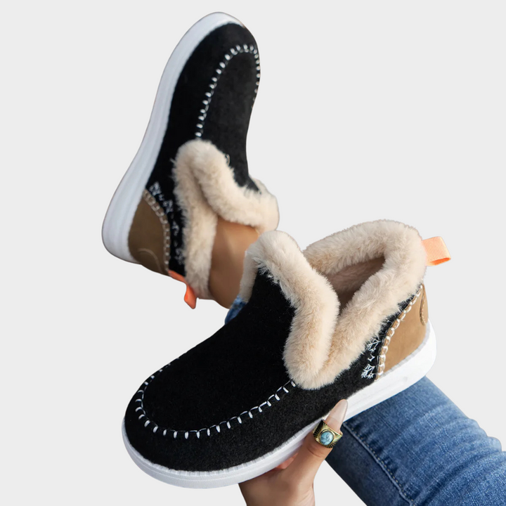 Cozy slip-on boots in black with faux-fur trim and white contrast stitching
