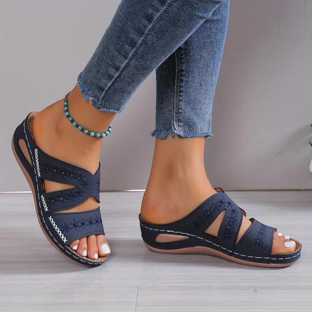 Orthopedic sandals with navy blue cross straps and open toe, stitched trim, cushioned sole