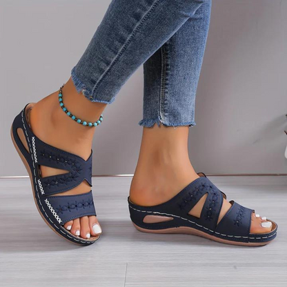 Orthopedic sandals with navy blue cross straps and open toe, stitched trim, cushioned sole