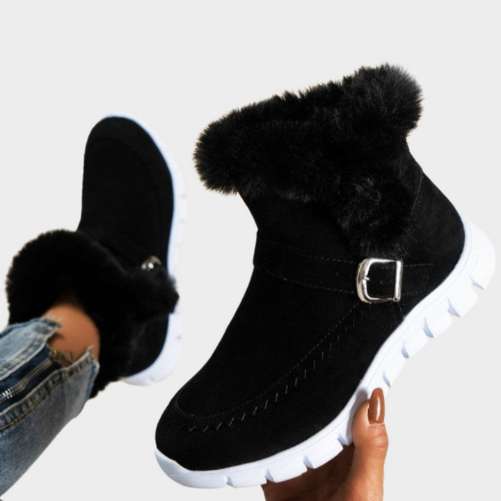 Warm boots in black with black faux-fur cuff, side zip, and buckle strap