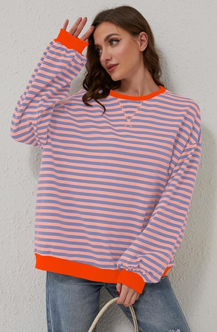 Striped sweater in light blue and pink horizontal stripes, orange ribbed cuffs and hem