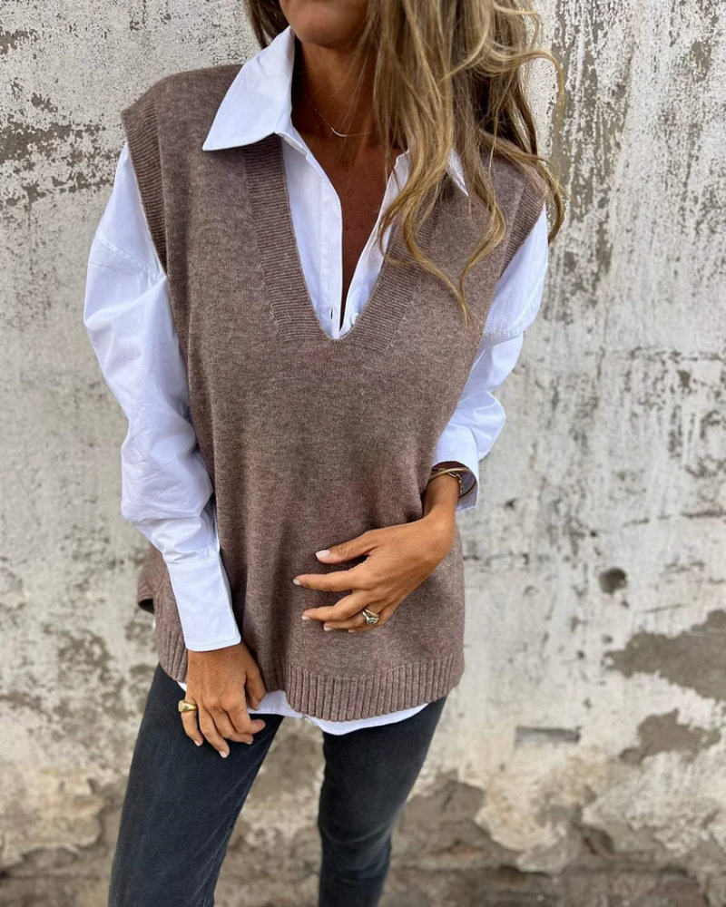 Dark brown knit sweater vest over a white button-down, V-neck sleeveless style.