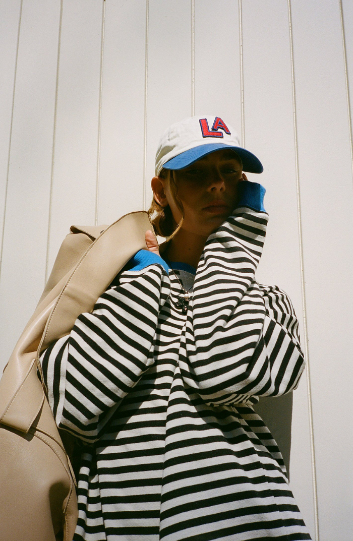 Black-and-white striped sweater with blue ribbed cuffs and wide neckline
