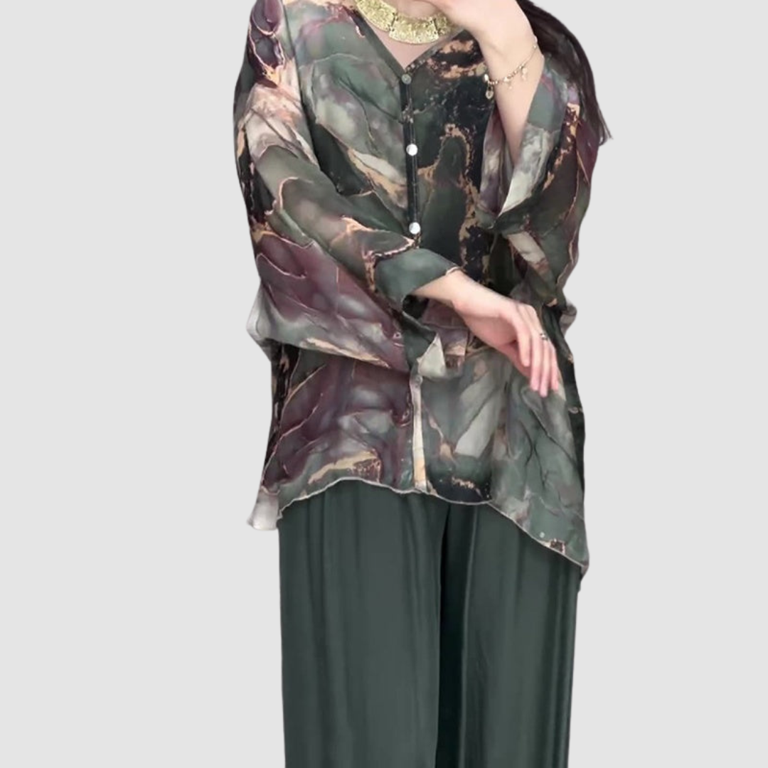 Printed blouse with button front over dark green wide-leg pants, abstract floral pattern