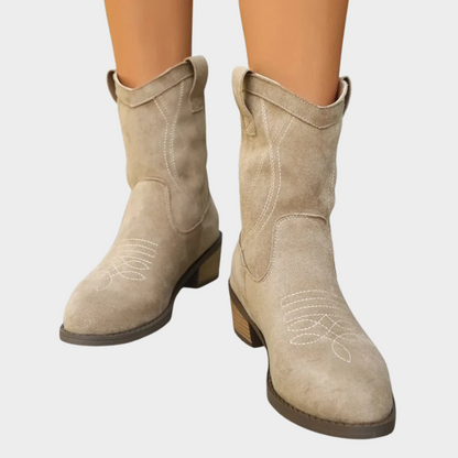 Gray suede cowboy-style ankle boots with stitched panels and low block heel