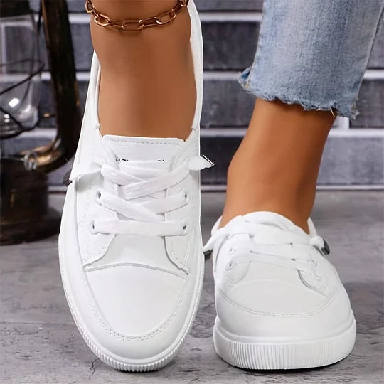 Pair of white lace-up orthopedic sneakers with side panel stitching and rubber sole