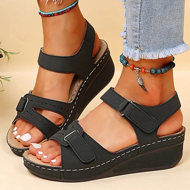 Women’s black platform sandals with two straps and adjustable buckles on wedge sole