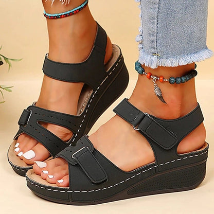 Women’s black platform sandals with two straps and adjustable buckles on wedge sole