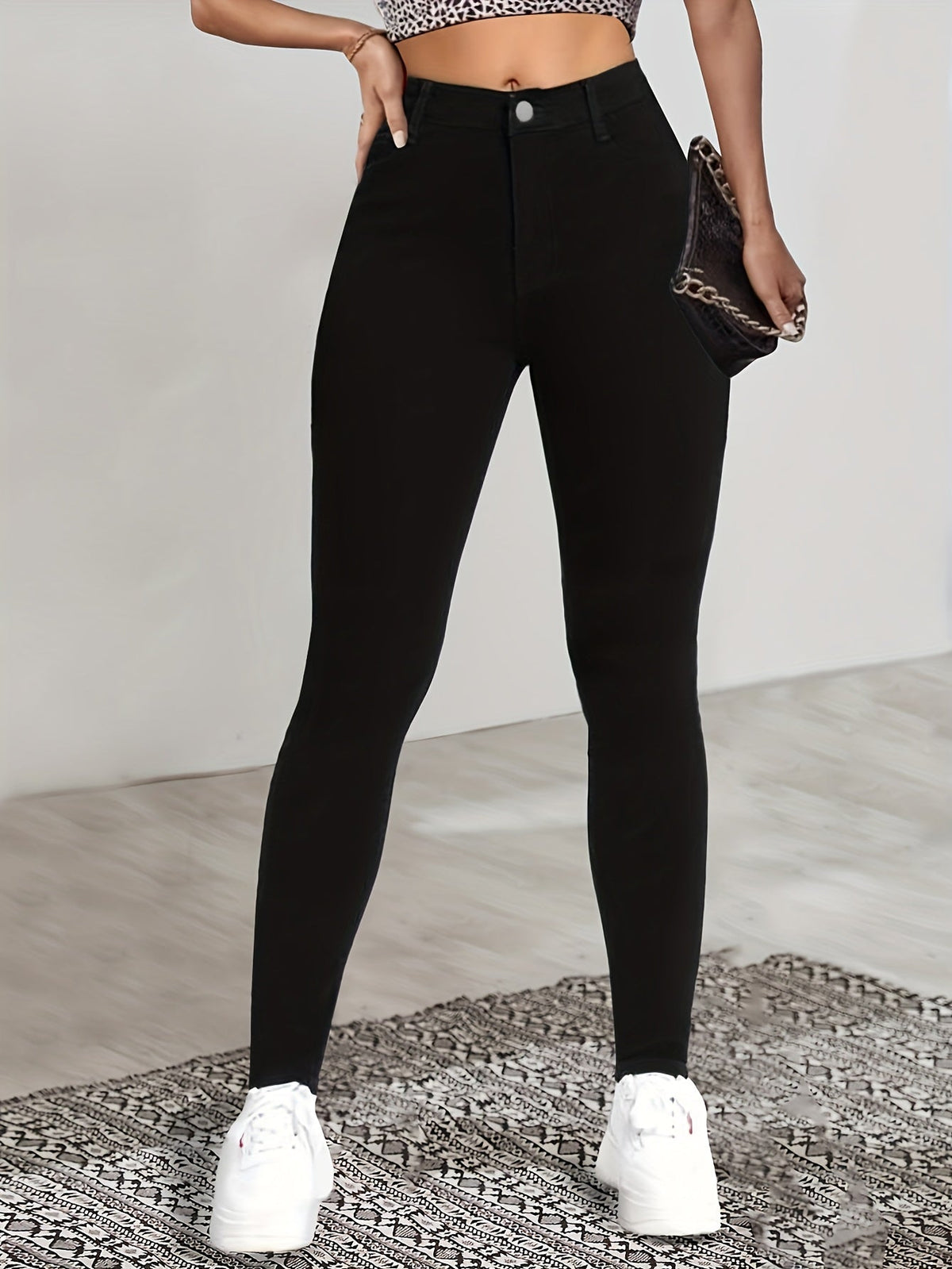 Black high-waist skinny jeans with front button, slim leg fit and side pockets