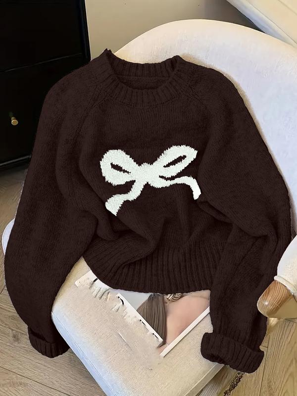 Dark brown knit sweater with ribbed crew neck, cuffs, and white bow intarsia