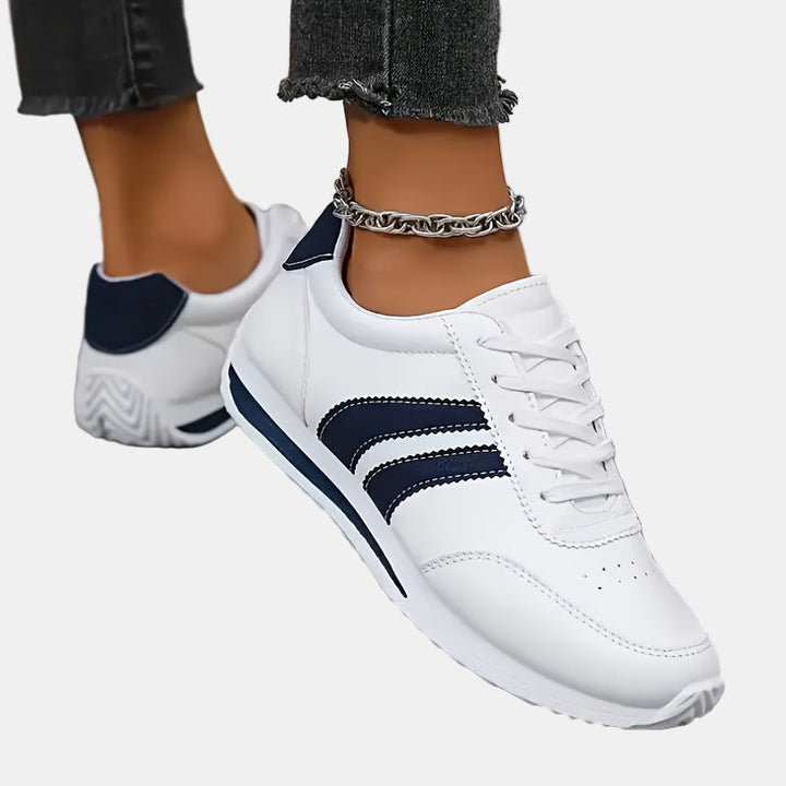 White orthopedic sneakers angled side view, navy stripes and chunky sole