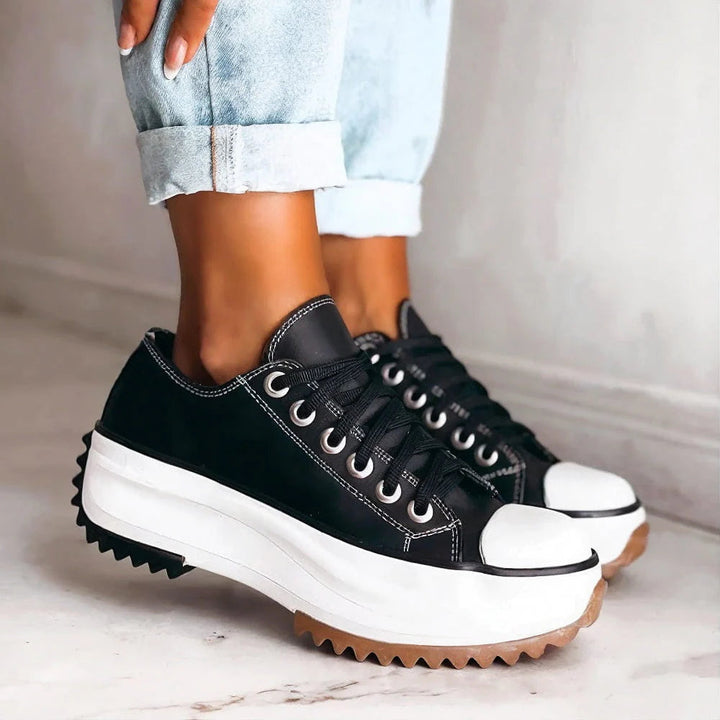 Black orthopedic sneakers with lace-up front, white midsole, textured outsole
