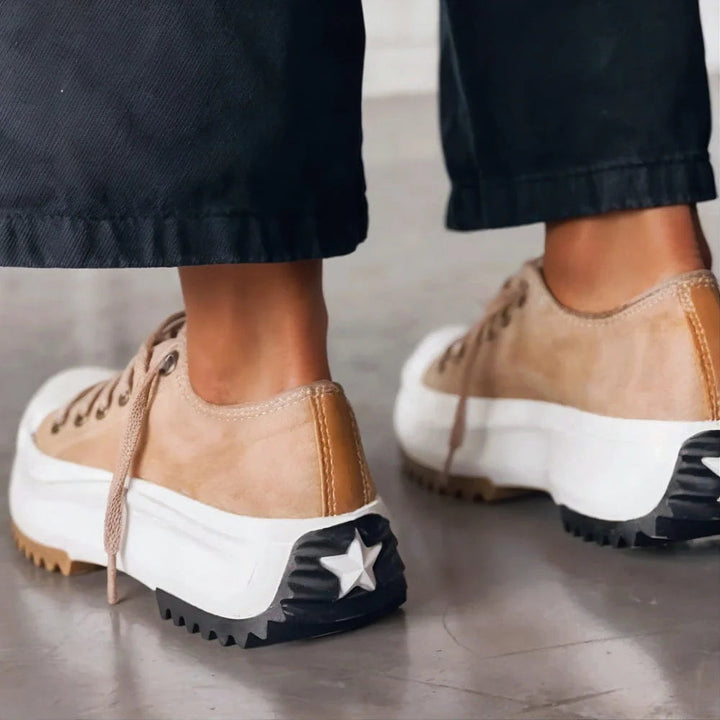 Tan orthopedic sneakers with lace-up design, white sole, star detail on heel