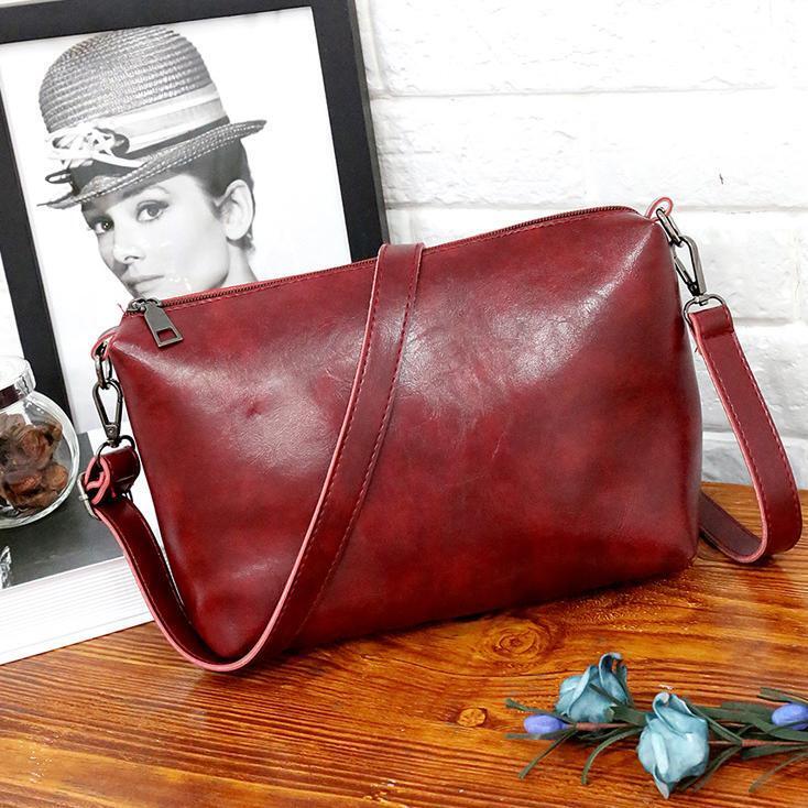 Red shoulder bag with adjustable strap and front zip pocket