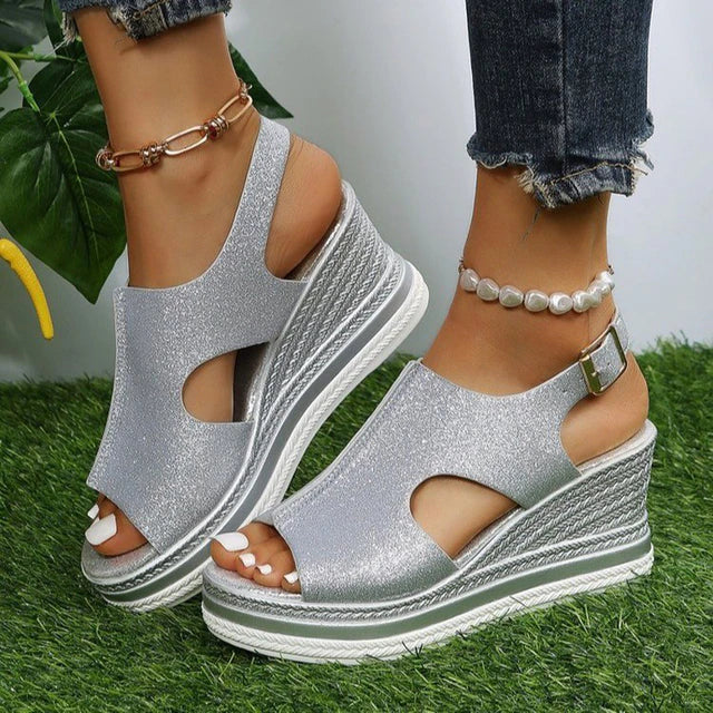 Silver glitter wedge sandals with ankle strap, chain detail, and peep-toe cutouts
