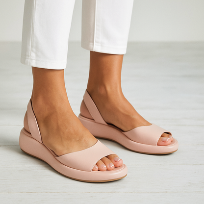 Blush pink open-toe wedge sandals with wide front strap and cushioned sole