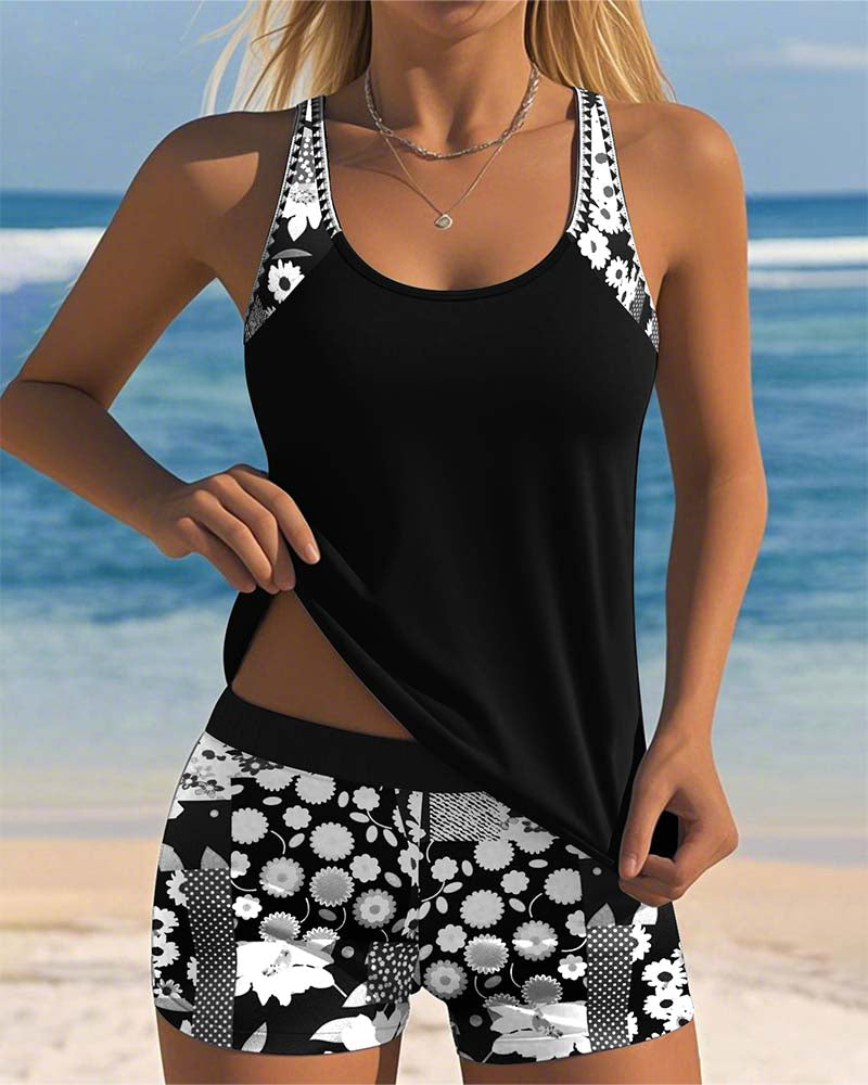 Black swimsuit tank top with printed boxer shorts, white floral accents on straps