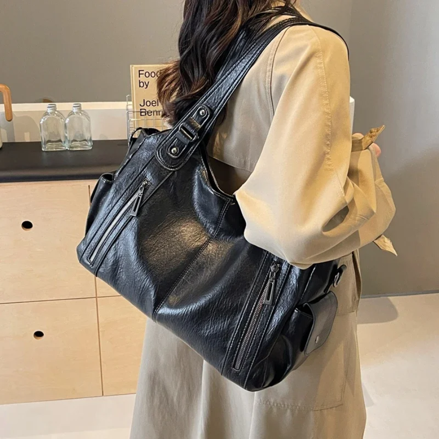 Black large shoulder bag carried crossbody with dual front zip pockets