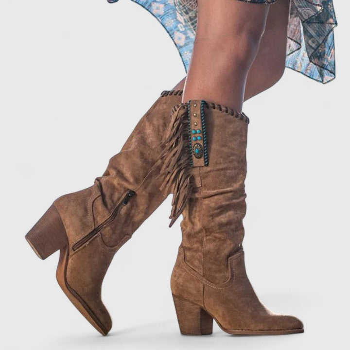 Brown suede block heeled boots with side zip tab, fringe tassels, and studs