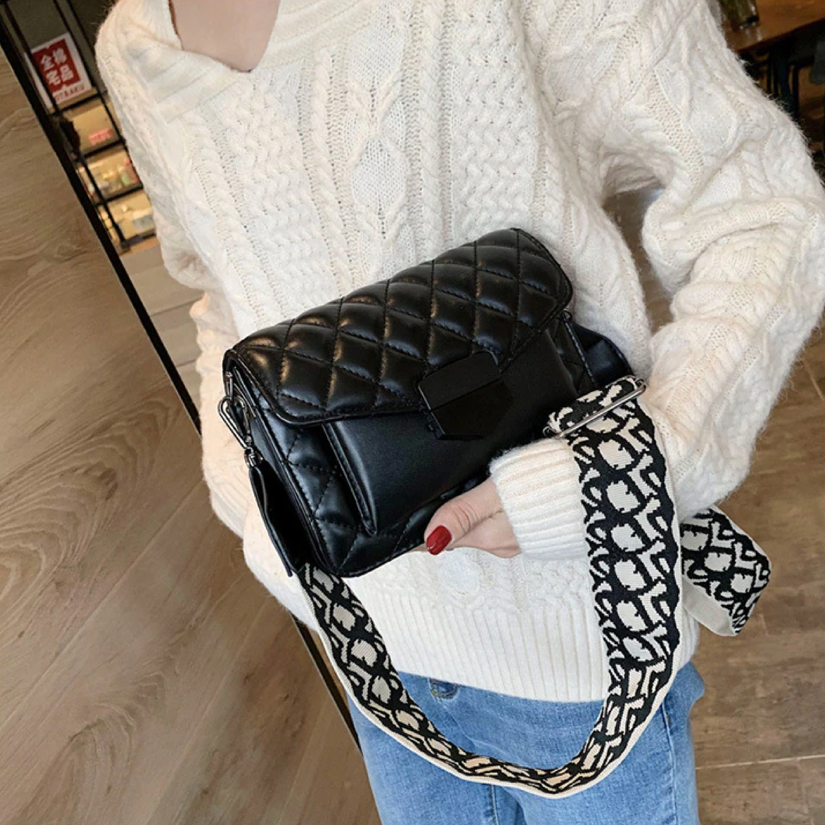 Black quilted leather shoulder handbag with chain strap and patterned trim
