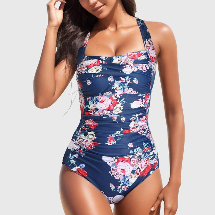 One-piece swimsuit, navy with red and white floral print and gathered ruching.