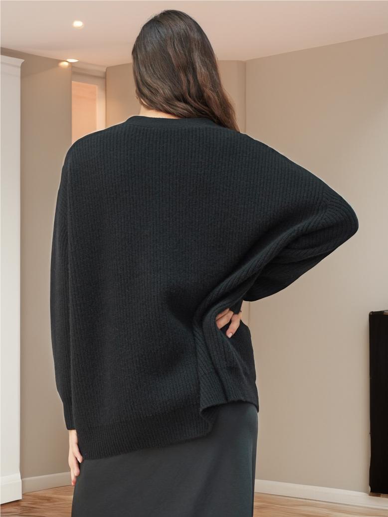 Black knit cardigan back view, relaxed cocoon shape, ribbed knit texture, long sleeves.