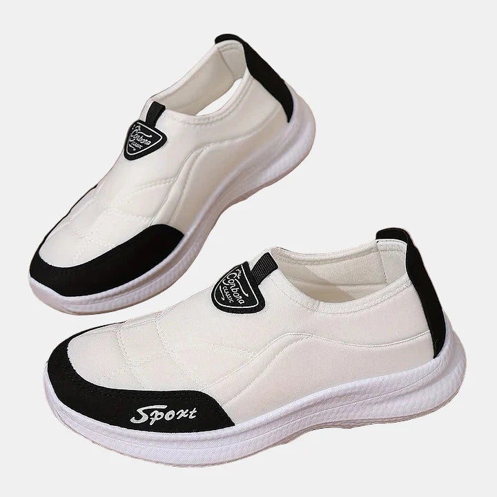 White slip-on sneakers with black side panel and cushioned white sole