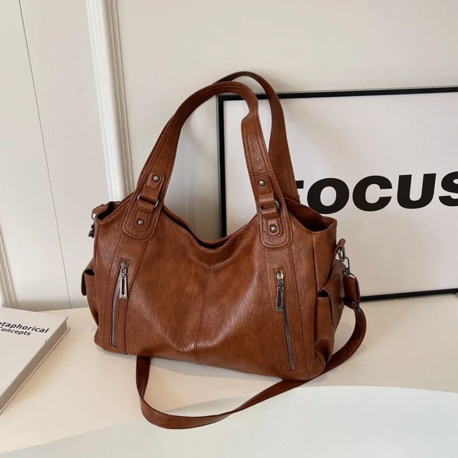 Brown large shoulder bag, side view, with crossbody strap and dual front zippers