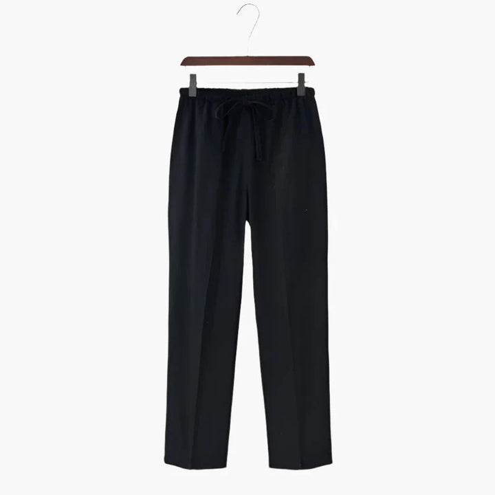 Black linen trousers hanging on hanger, elastic drawstring waist, relaxed straight legs