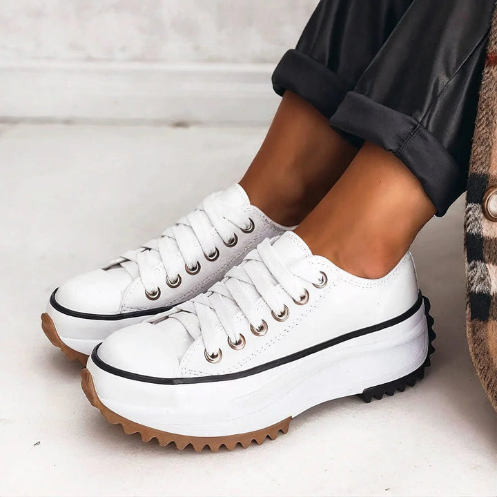 White orthopedic sneakers with lace-up front and brown rubber outsole