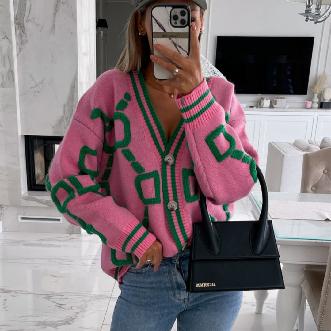Pink button-down cardigan with green geometric pattern, V-neck, long sleeves, button front