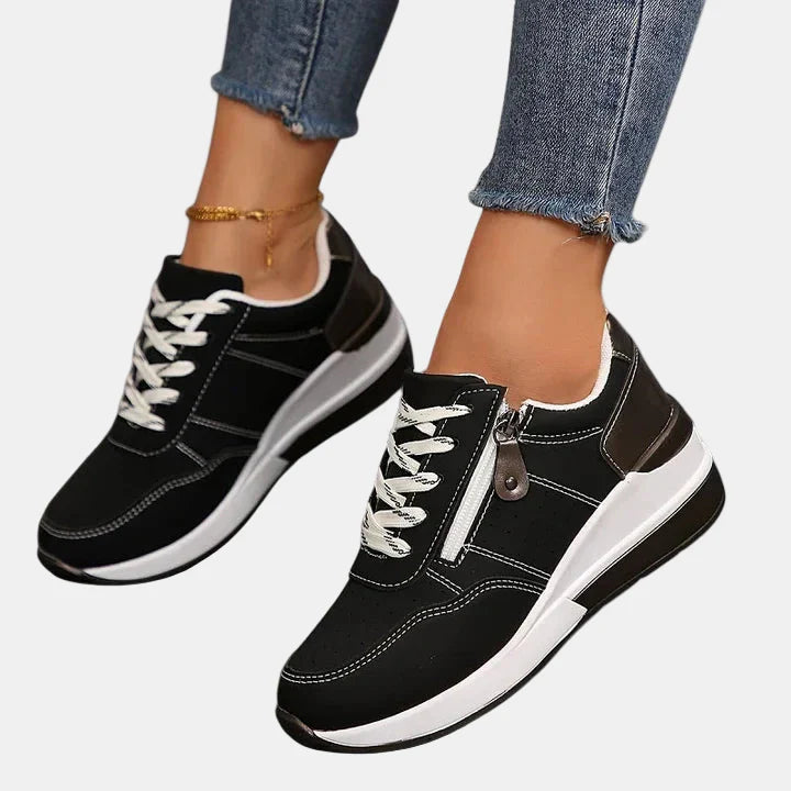 Orthopedic shoes in black with white laces and stitched panels, thick white sole