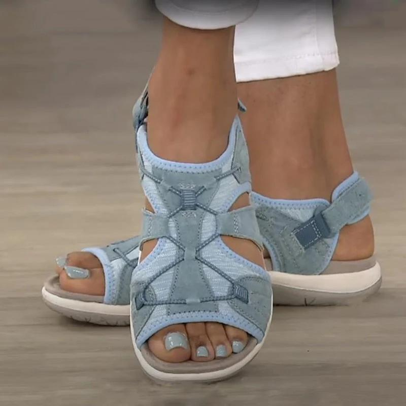 Light blue orthopaedic sandals with cross-laced straps, buckle strap, and thick sole