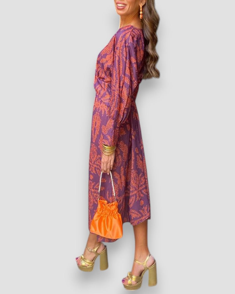 Purple V-neck wrap dress with long sleeves, patterned tie waist, and ornate print.