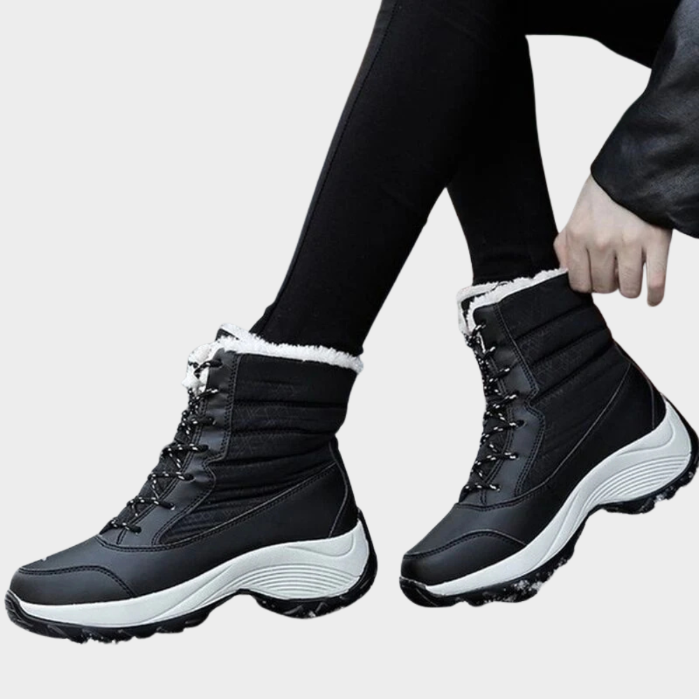 Black winter boots with lace-up front, cushioned collar, white faux-fur cuff, tread sole.