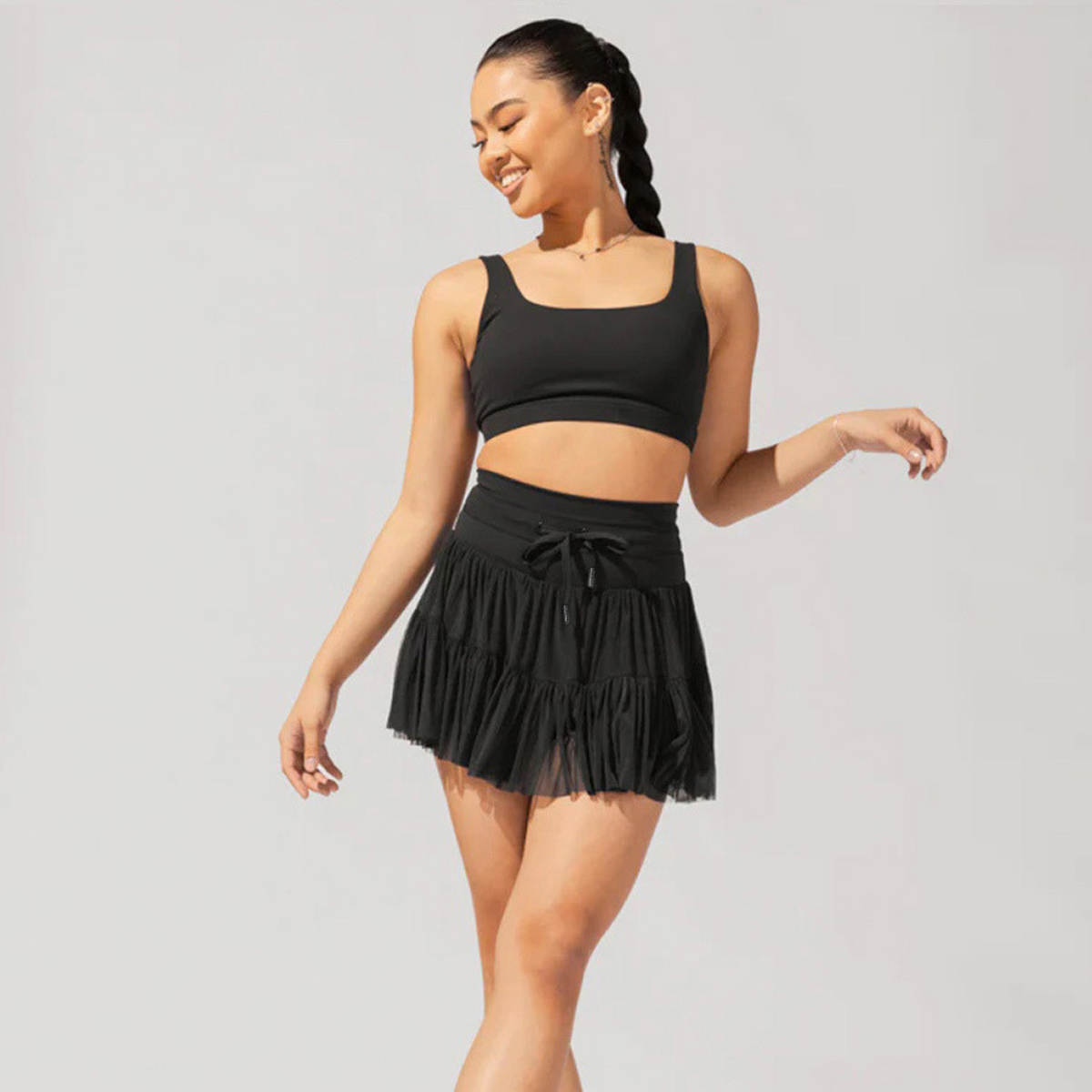 Black high-waist pleated skort with drawstring waist and tiered ruffle skirt