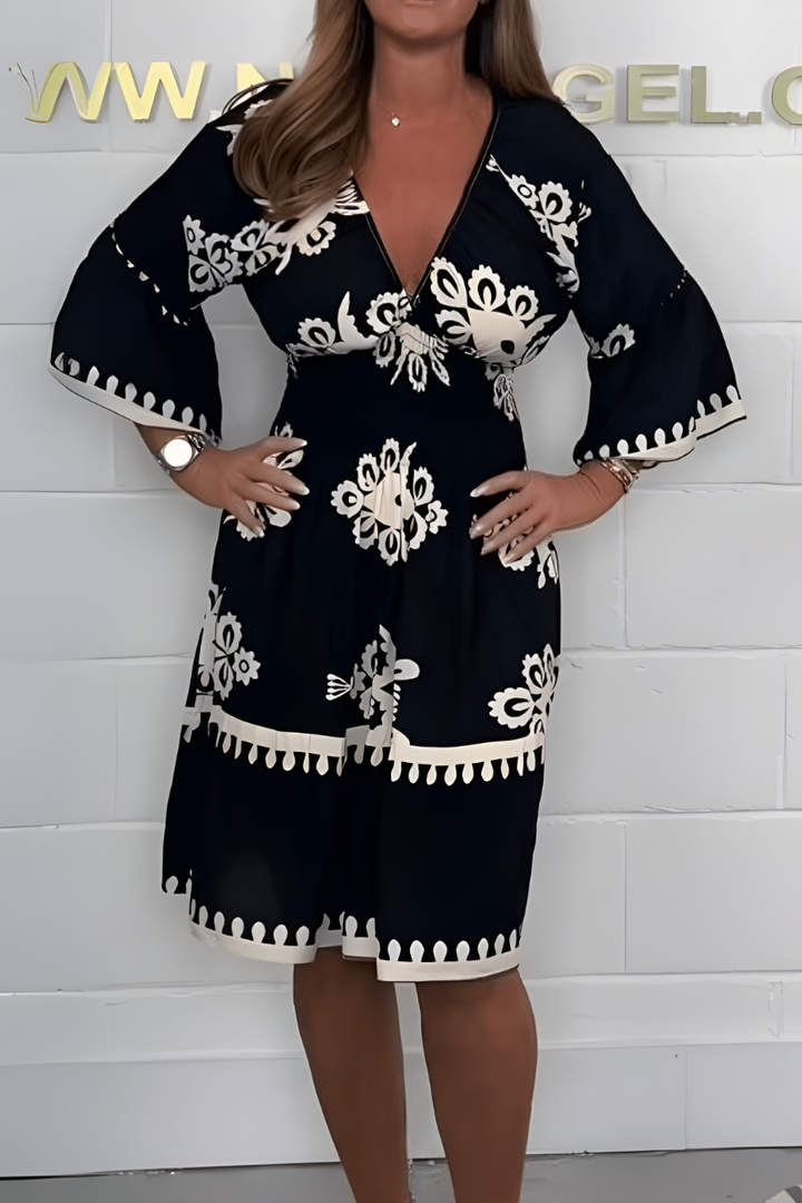 Black knee-length dress with white embroidered florals and tassel-trim edge detailing