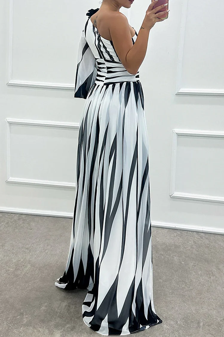One-shoulder maxi dress in white with black stripes, pleated skirt, side slit