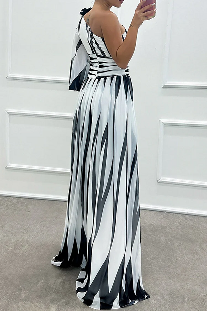 One-shoulder maxi dress in white with black stripes, pleated skirt, side slit