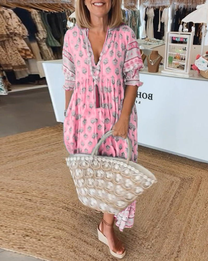 Pink floral V-neck maxi dress with ruffled sleeves and tiered hem, side view