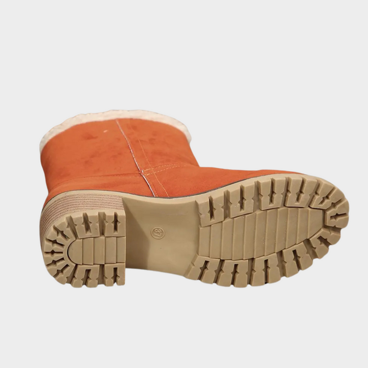 Orange winter boot outsole with deep tread and stacked heel for traction