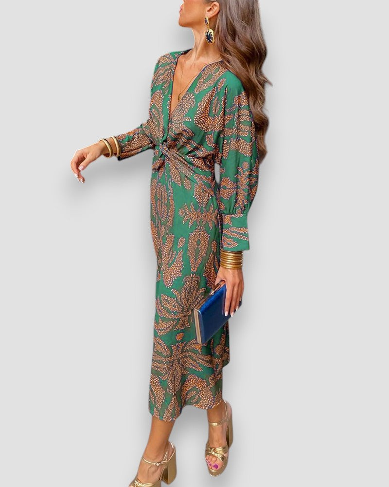 Green V-neck wrap dress with long sleeves, gold tie waist, and ornate leaf print.