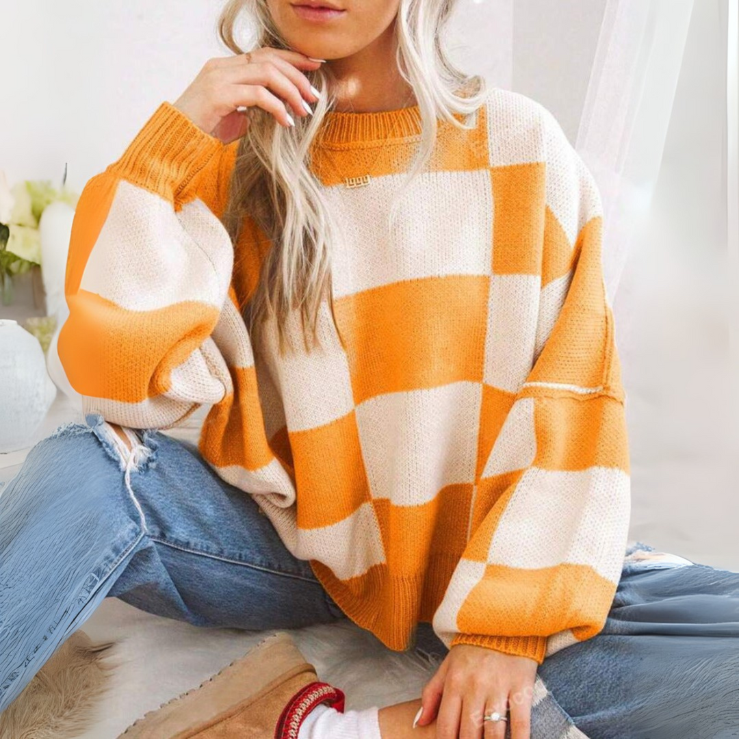 Orange and white checkered crewneck long-sleeve knit sweater with ribbed cuffs