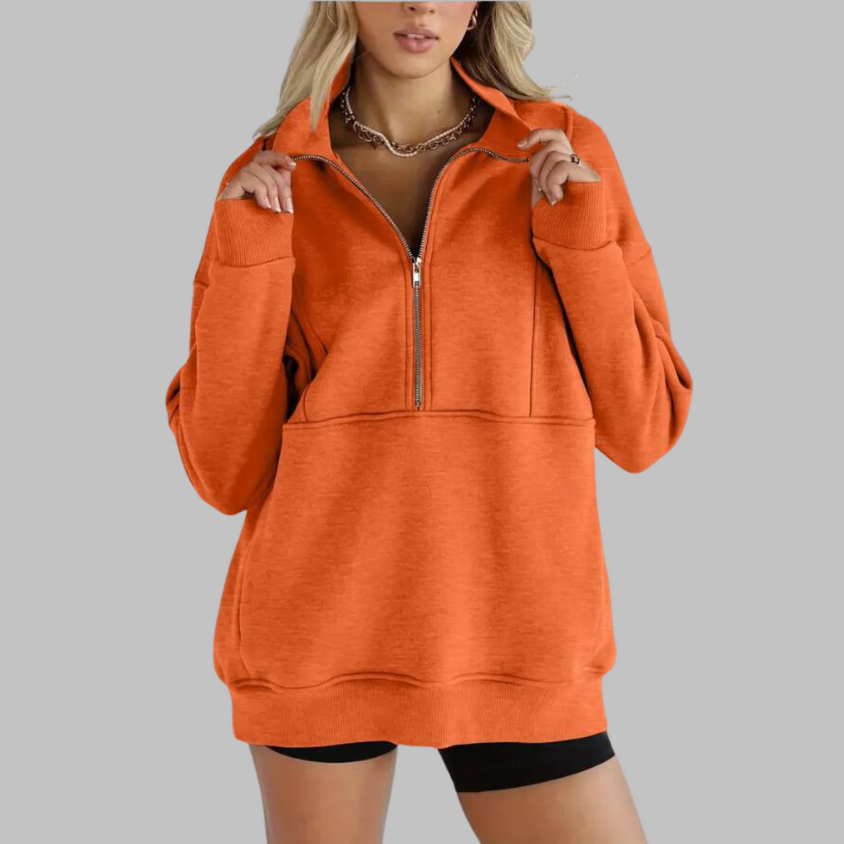 Orange oversized half-zip sweatshirt with front zipper and kangaroo pocket, ribbed cuffs