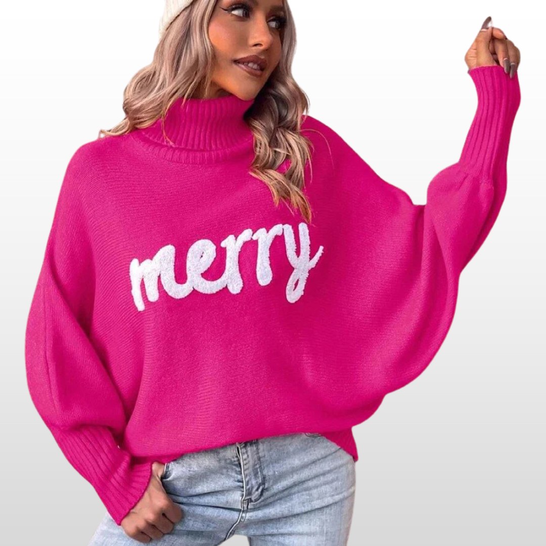 Pink knit turtleneck sweater with batwing sleeves and white “Merry” print