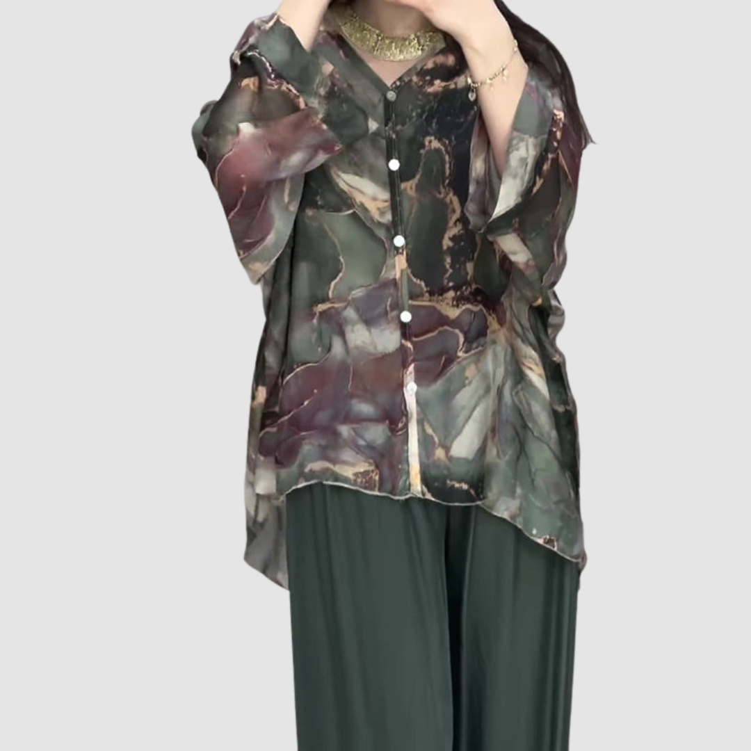 Printed blouse with V-neck and long sleeves over dark green wide-leg pants, abstract floral print