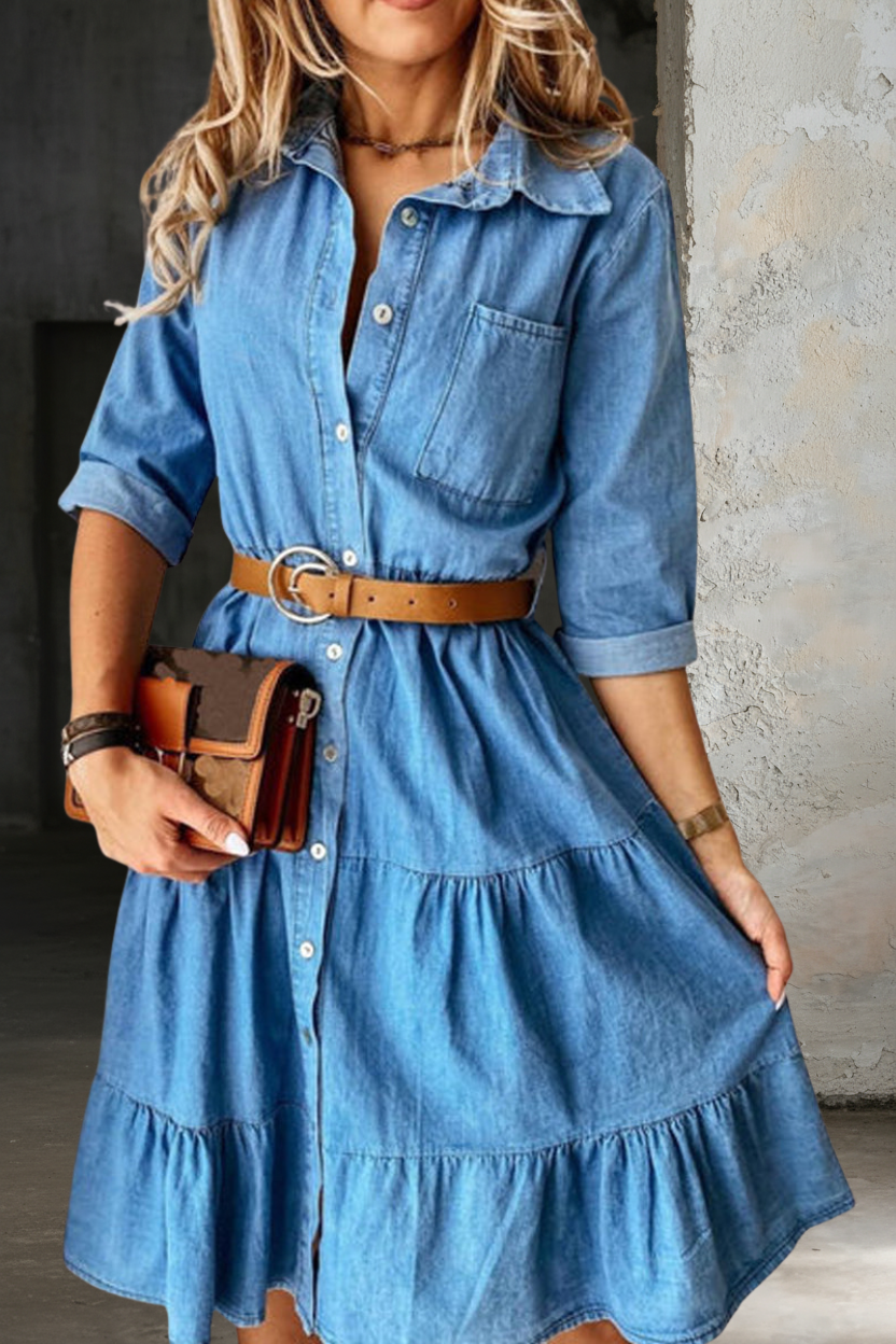 Light blue denim shirt dress detail: button placket, tiered skirt, waist belt.