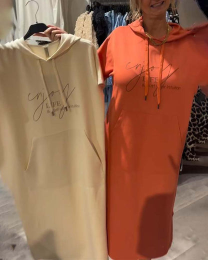 Long hooded dresses on hangers, cream and orange, short sleeves and drawstring hood