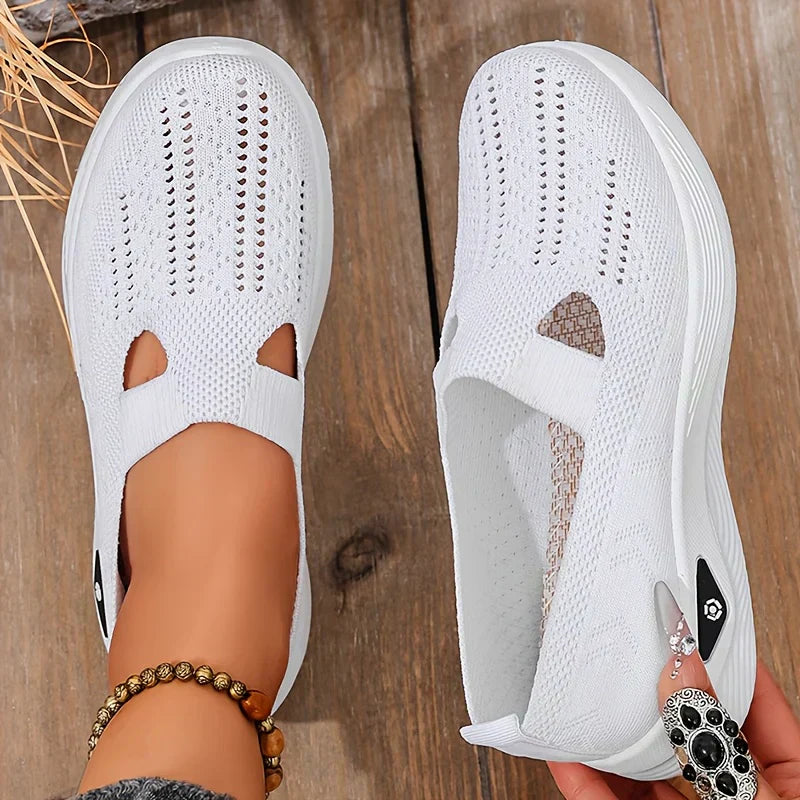 White orthopedic slip-on shoes with knit upper, cutout openings, and cushioned outsole