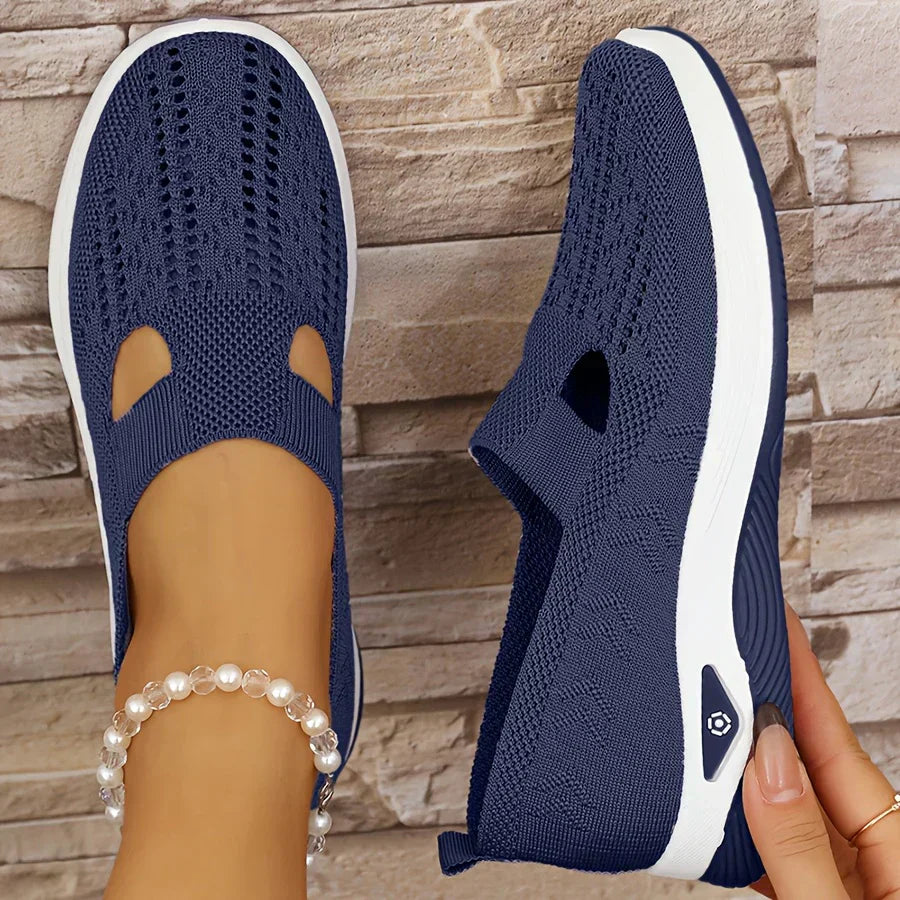 Navy orthopedic slip-on shoes with knit upper, cutout openings, and white cushioned sole